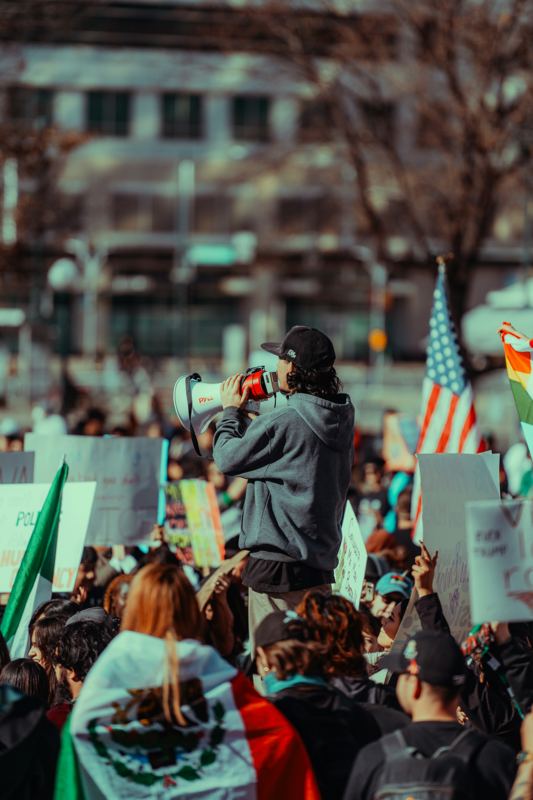 Speaker addressing a crowd with a megaphone at a rally